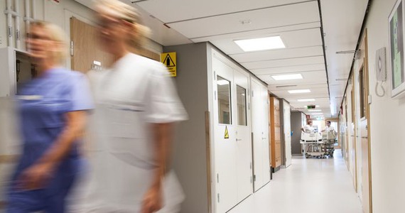 Två vårdpersonal går framåt i en vårdkorridor.