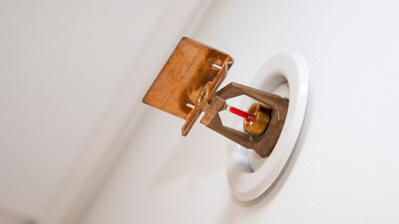 En närbild av en sprinkler på en vägg.