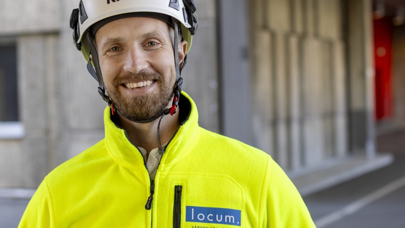 En bild på projektledaren Joel i hjälm och gul jacka.