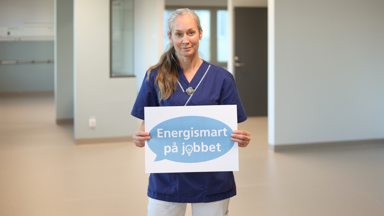 Kvinna i v&aring;rdkl&auml;der h&aring;ller i lapp d&auml;r det st&aring;r Energismart p&aring; jobbet.