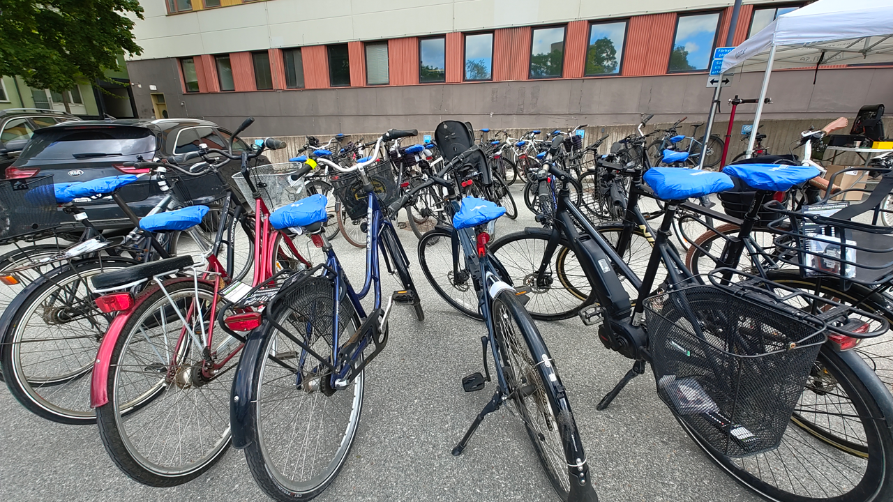 En grupp cyklar parkerade bredvid varandra.
