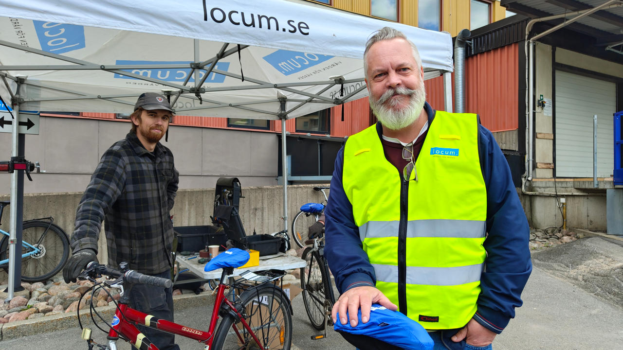 Fastighetsförvaltare som står bredvid en cykel och cykelmekaniker.