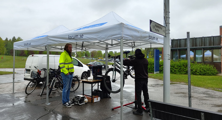 En Locummedarbetare och cykelmekaniker står under ett tält.