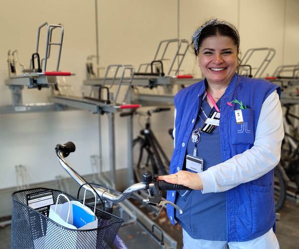 En kvinna står bredvid en cykel i ett cykelgarage.
