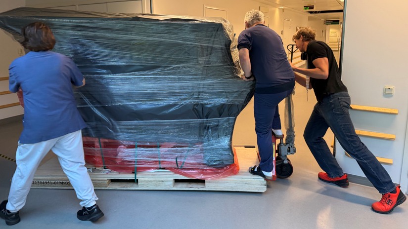 Tre personer puttar p&aring; leveransen.