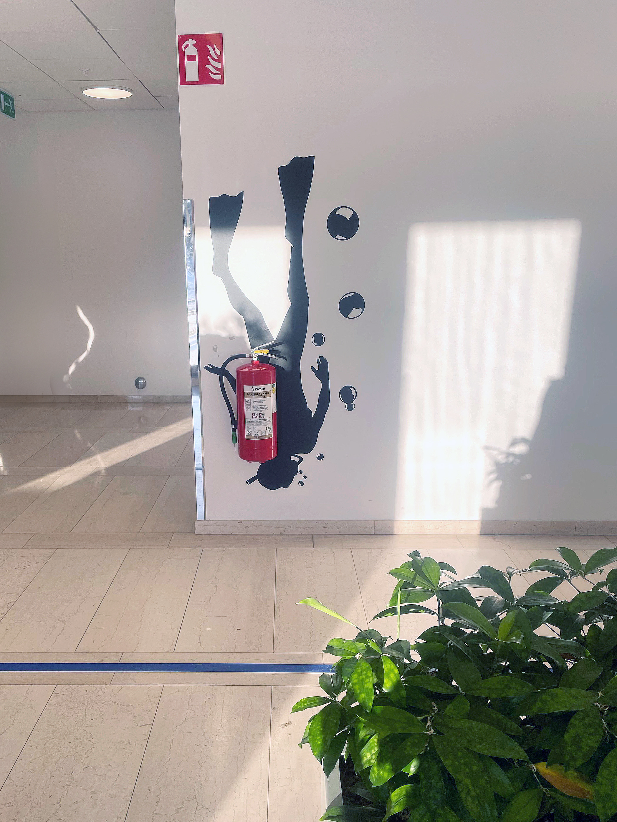 Väggfoliering av en dykare där syrgastuben är en brandsläckare.
