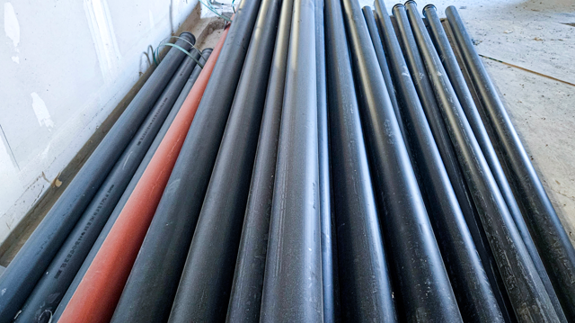 En hög med avloppsrör som ligger bredvid varandra.