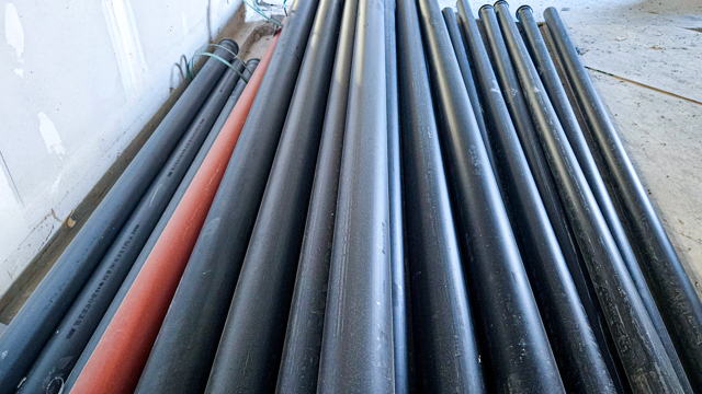 En hög med avloppsrör som ligger bredvid varandra.