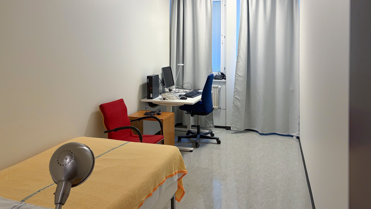Ett rum med säng, skrivbord, stol och dator.
