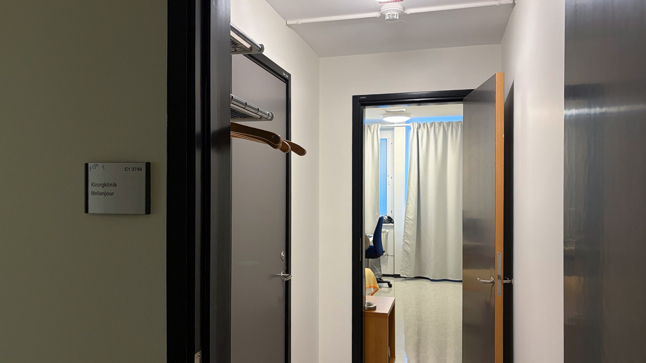 En hall som leder till ett sovrum med en öppen dörr.