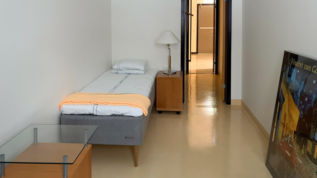 Ett sovrum med en säng, ett bord och en tv.