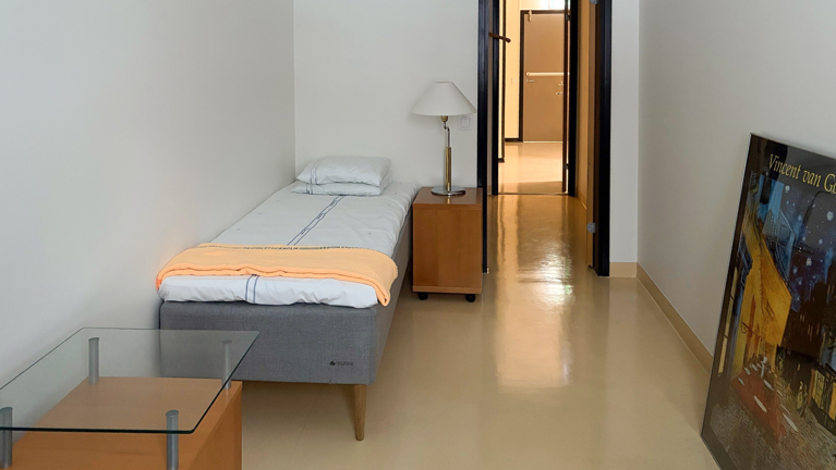 Ett sovrum med en säng, ett bord och en tv.