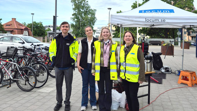 Representanter från Locum står vid en cykelparkering under cykeldagen på Sollentuna sjukhus.