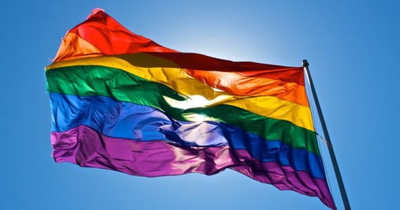 Prideflagga mot en blå himmel.