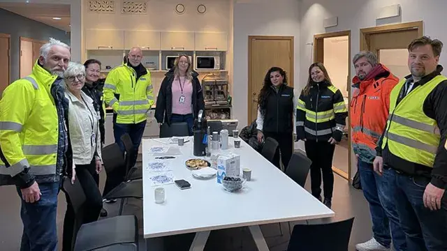 En grupp människor som står runt ett bord.