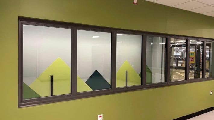 Ett rum med en grön vägg och flera fönster.