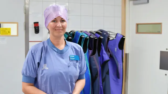 Lina Papunen med operationskläder utanför operationsal.