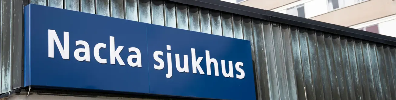 Skylt med Nacka sjukhus på fasad.