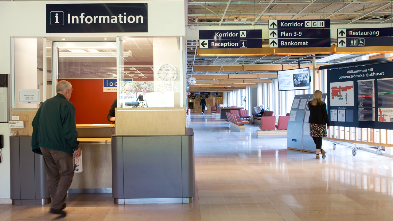 Informationdisken p&aring; L&ouml;wenstr&ouml;mska sjukhuset med m&auml;nniskor i g&aring;endes i korridorerna.