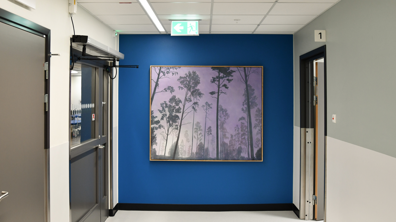 En hall med blå väggar och en tavla på väggen.