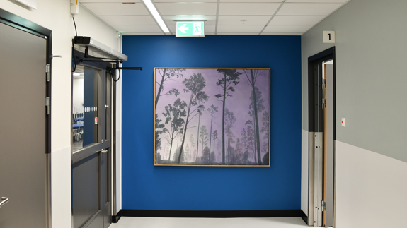 En hall med blå väggar och en tavla på väggen.