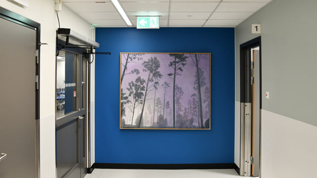 En hall med blå väggar och en tavla på väggen.