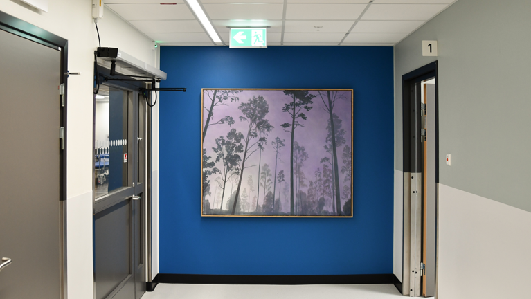 En hall med blå väggar och en tavla på väggen.