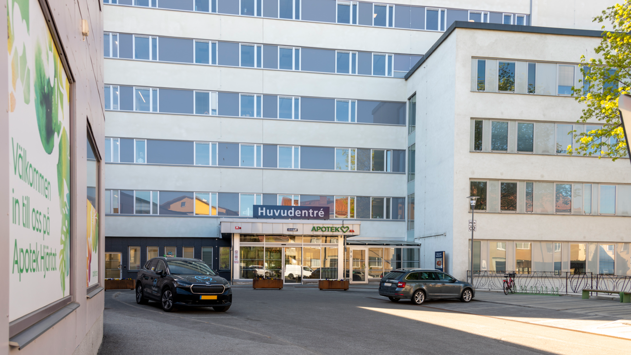 Stor byggnad med parkering och några bilar