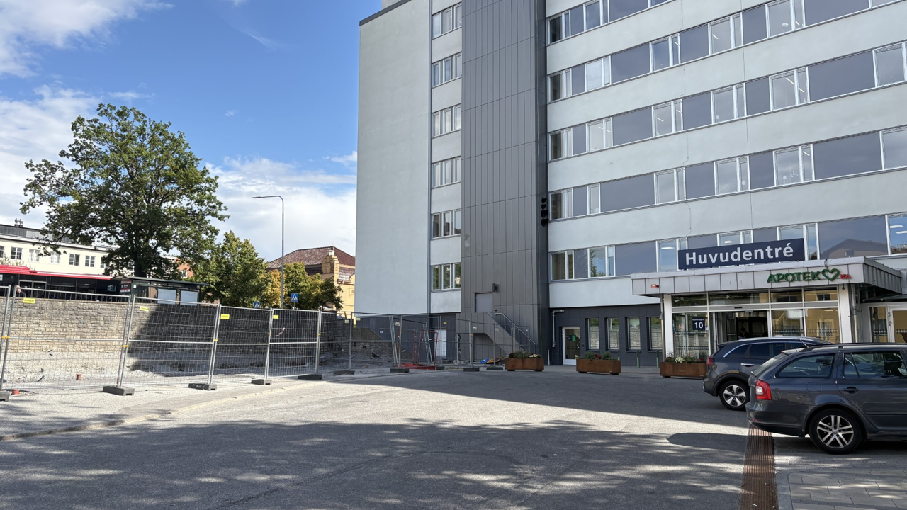 En parkeringsplats med bilar som står parkerade framför en byggnad.