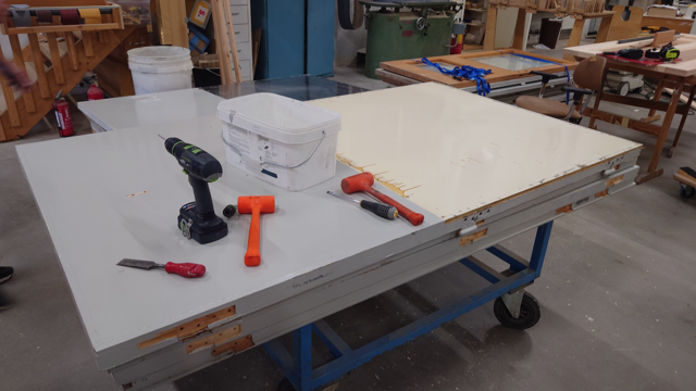 En d&ouml;rr som ska behandlas och st&aring;r p&aring; bock. P&aring; d&ouml;rren finns verktyg.