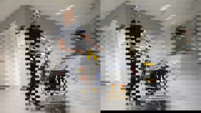 Driftpersonal åker sparkcykel i sjukhuskorridor.