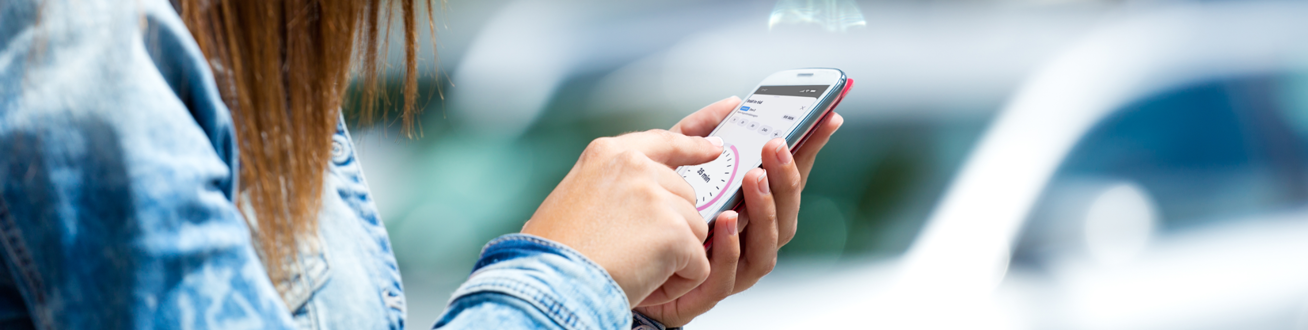 En kvinna ska starta parkering på sin mobiltelefon.