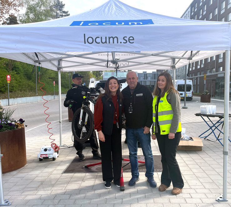 Tre Locummedarbetare som står under ett vitt tält och en cykelmekaniker står bakon.