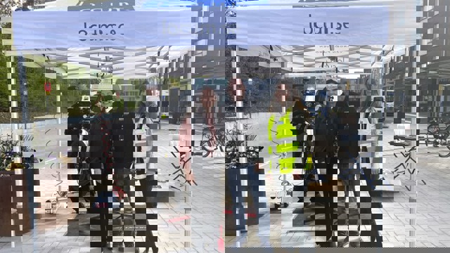 Tre Locummedarbetare som står under ett vitt tält och en cykelmekaniker står bakon.