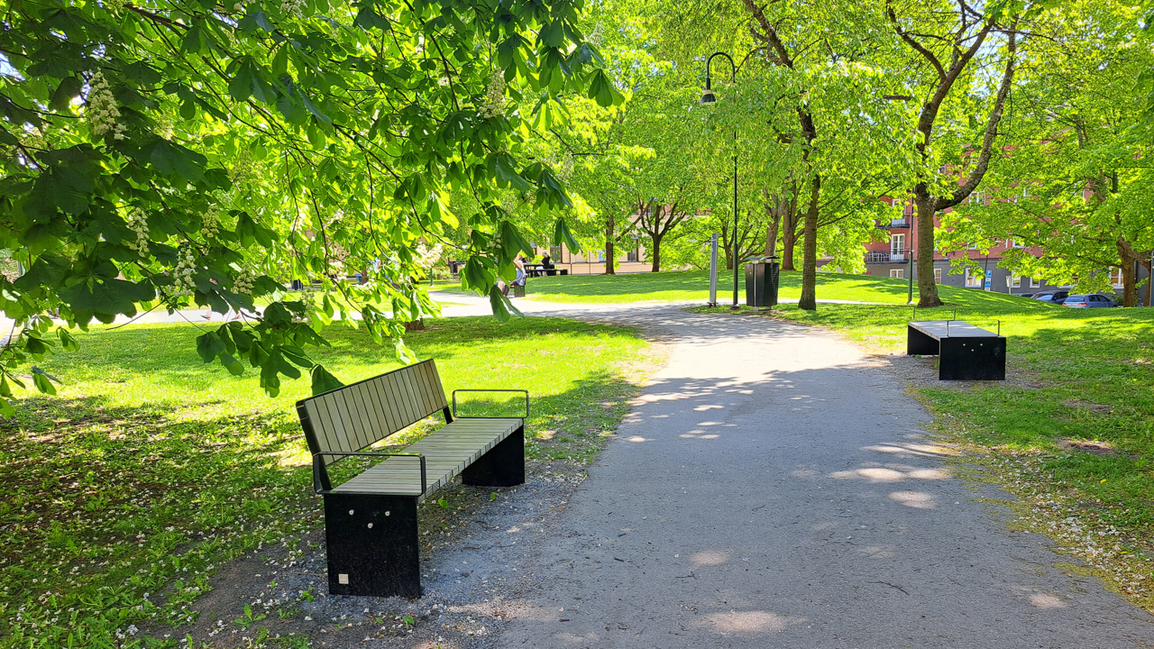 Del av sjukhuspark med gång och parkbänkar vid Rosenlunds sjukhus.