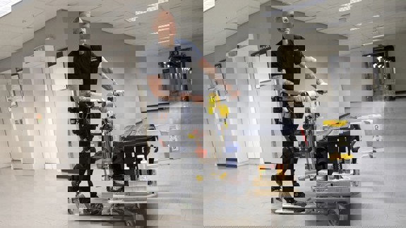 Driftpersonal åker på cykelscooter inne i en korridor.