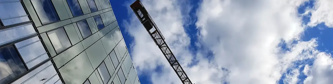 Byggkran, fasad och himmel.