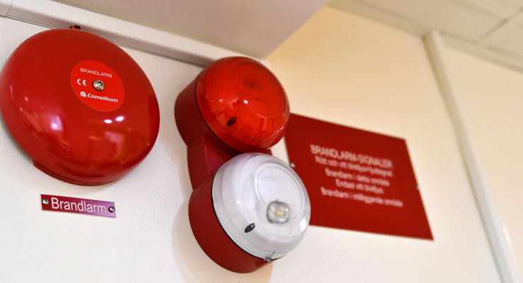 Brandlarm uppsatt p&aring; en v&auml;gg.