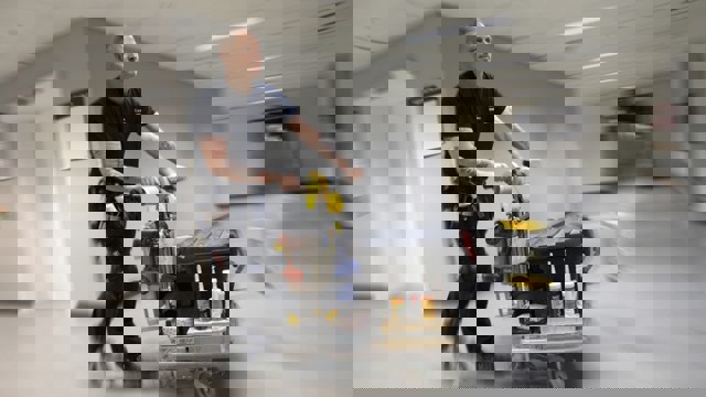 Driftpersonal som åker på en sparkcykel i en sjukhuskorridor.