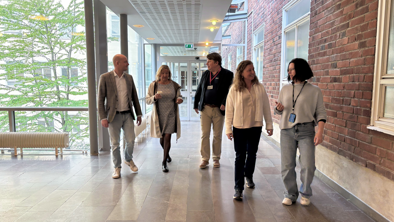 En grupp människor som går längs en korridor.