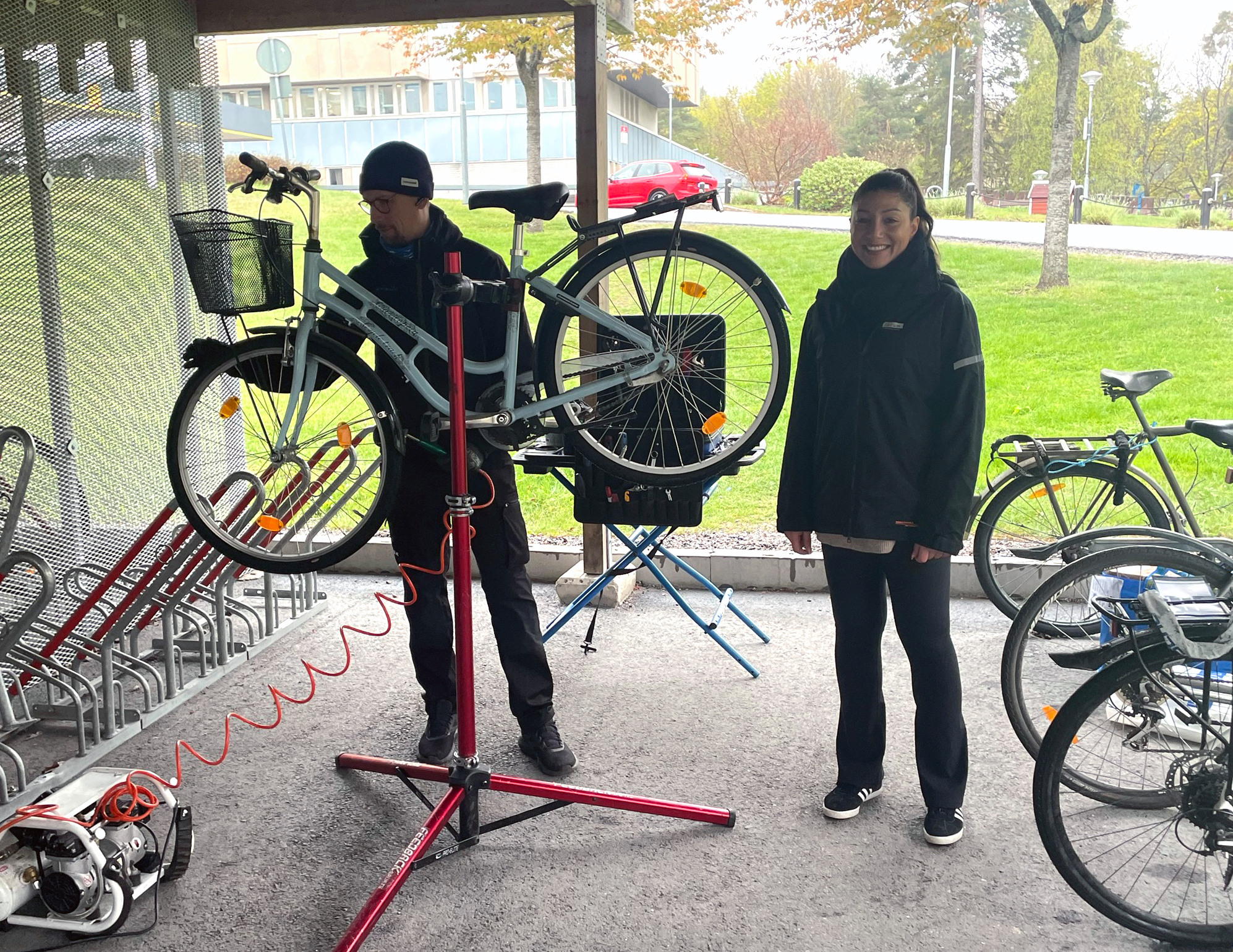 Fastighetsförvaltare står bredvid cykelmekaniker vid ett cykelgarage.