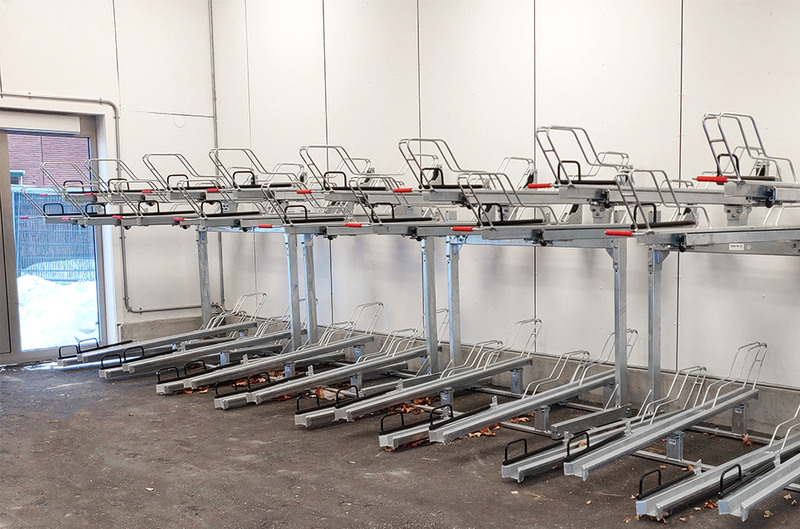 Cykelställ i två nivåer inne i cykelgarage.