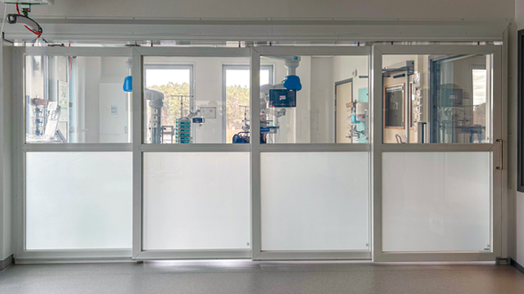 Ett rum med en stor glasvägg  som fungerar som avskiljare med en så kallad mjölkfunktion.