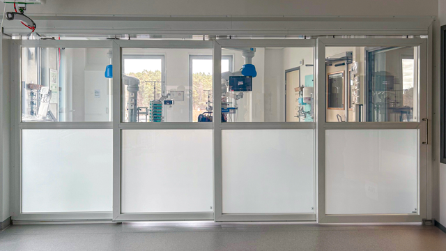 Ett rum med en stor glasvägg  som fungerar som avskiljare med en så kallad mjölkfunktion.