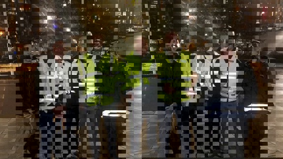 Fem personer står utomhus i mörker för att gå trygghetsrondering runt sjukhuset.