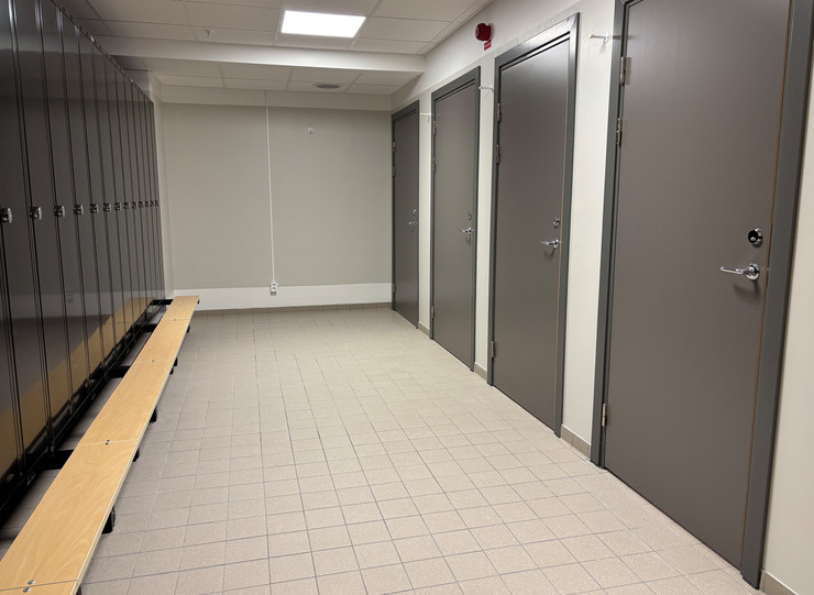 Del av nytt omkl&auml;dningsrum med svarta sk&aring;p och gr&aring; d&ouml;rrar till toaletter.