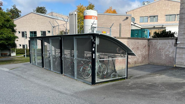 Inhägnad cykelparkering med gallerväggar.