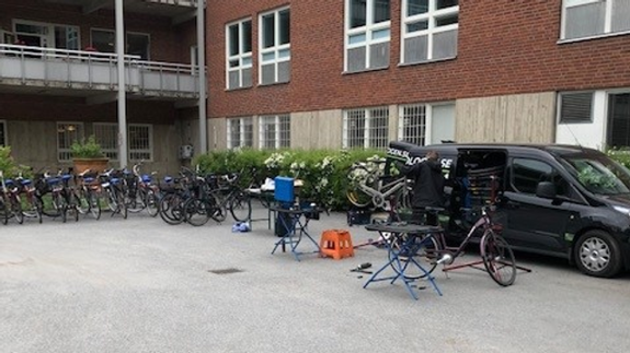 En parkeringsplats med ett gäng cyklar parkerade framför en byggnad.