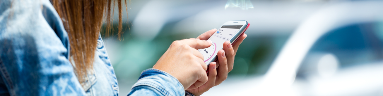 En kvinna ska starta parkering på sin mobiltelefon.