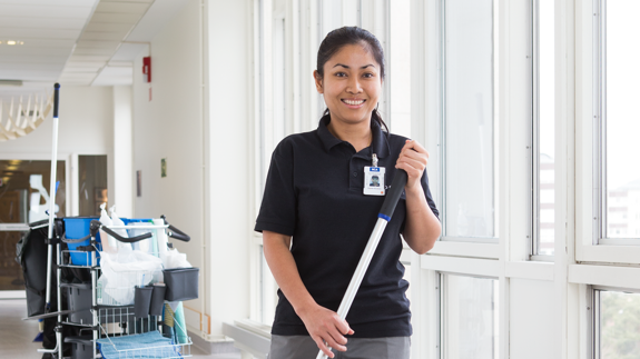 Kvinnlig lokalvårdare i sjukhuskorridor.